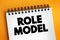 Role model - person whose behaviour, example, or success is or can be emulated by others, text concept on notepad