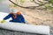 A roll of cloth to protect the surface of the soil, unwinding a worker in a blue uniform and a white helmet at a construction site