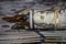 A roll of dollars on the background of scattered hundred dollar bills and various coins
