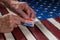 Roll of I Voted Today paper stickers on US Flag with hand removing one