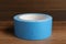 Roll of light blue adhesive tape on wooden table, closeup