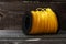 Roll of polymer yellow fishing line for grass trimmer on an old wooden background with copy space