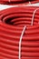 Roll of red flexible plastic pipes
