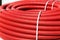 Roll of red flexible plastic pipes