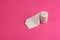 Roll of rough white toilet paper stand on pink background, close-up, copy space, concept of stomach problems