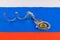 roll of russian paper rubles currency and bitcoin shiner chained with handcuffs on russian flag background