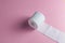 A roll of toilet paper isolated on the pink background