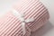 Roll up pink throw fleece fabric with lines on white background, closeup