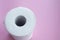 Roll of white disposable nonwoven fabric napkins isolated on pink