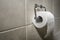 Roll of white toilet paper on metal paper holder. White and soft toilet paper on metal holder. Tissue roll in the toilet
