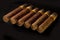 Rolled cigars from a tobacco leaf on a black background, Small depth of sharpness