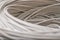 A rolled gray cable is a close up. A bunch of utp wires intertwined with each other. Abstract technological background texture.