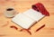 Rolled necktie, diary, watch, cup of coffee and pen on wooden table. Selective focus