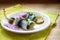 Rolled pickled herring, also called rollmops with red onions, gherkins and capers as a traditional hangover breakfast on a white