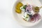 Rolled pickled herring, also called rollmops with red onions, gherkins and capers, a sour hangover breakfast on a white table,