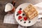 Rolled thin pancakes with berries and milk on wooden table