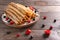 Rolled thin pancakes with berries on wooden board