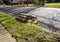 Rolled up carpet and under padding in a street by a curb waiting for trash pickup on a suburban street neat a storm sewer