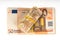 Rolled up euros with rubber on the fifty euro banknotes pile. Money bunch stack