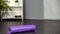 Rolled up yoga mat lying on floor, sports equipment, home training, health