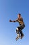 Roller boy jumping from parapet on the blue sky