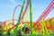 Roller coaster with turns, turns, cave, loops in a summer amusement park