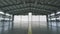 Roller shutter door and concrete floor inside factory building for industrial background. Airplane in front of half