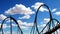 Rollercoaster silhouette animation loop against sheep clouds blue sky