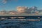 Rolling cloudscape over seawaves at sunset