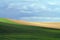 Rolling Farm Fields Under a Cloudy Sky