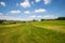 Rolling landscape with fence, windmills and blue sky