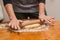 Rolling out cookie dough with a wooden splinter on the table