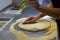 Rolling out pizza bases from dough with pizza hands
