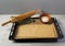 A rolling pin and delicate dough on a baking sheet, beside a ceramic bowl with sweet filling