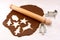 Rolling pin and festive cookie cutters with gingerbread dough