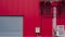 Rolling shutter door with Hvac air ventilation system on red aluminum corrugated wall of industrial building