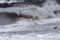 Rolling waves on stone coastline at stormy weather