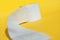 Rolls of new toilet paper lie on a yellow background