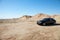 Rolls Royce car parked on unpaved road in front of mountains