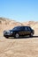 Rolls Royce parked on unpaved road with clear sky