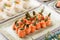 Rolls of salmon fish with cream cheese, shrimp and asparagus on banquet table. Delicious appetizers, gourmet food close up