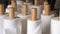 Rolls of white paper hand towels stand on wooden racks on the table, napkins in a restaurant or dining room for visitors.