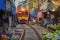 Rom Hoop market. Thai Railway with a local train run through Mae Klong Market in Samut Songkhram Province, Thailand. Tourist