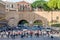 Roma, Italy - October 2015: A large crowd of pedestrians tourists passes through a pedestrian crossing a busy street with traffic