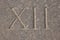 Roman numeral - twelve carved in stone