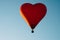 The romance of flying in a balloon in the shape of a red heart.