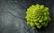 Romanesco broccoli head on a dark stone surface