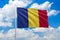 Romania national flag waving in the wind on clouds sky. High quality fabric. International relations concept
