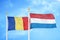 Romania and Netherlands two flags on flagpoles and blue sky