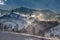 Romanian hillside and village in winter time , mountain landscape of Transylvania in Romania